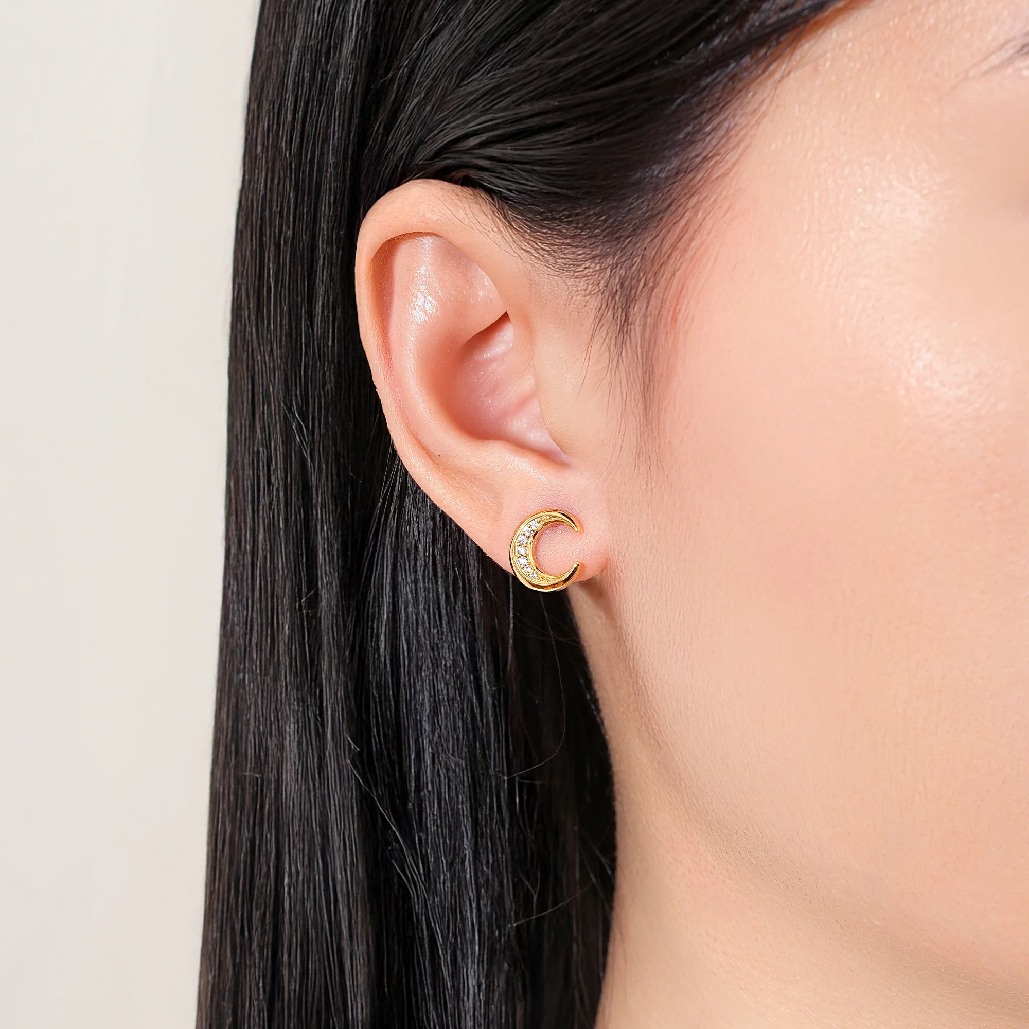 At the time, Muna Gold Moon stud earrings made of 925 sterling silver, 18K gold plated and with white cubic zirconia